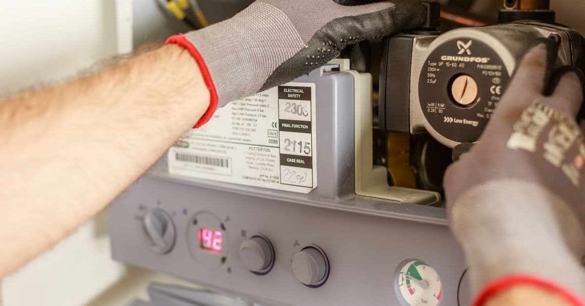 Handwerker installiert eine Wärmepumpe im Heizungskeller als eine der zulässigen Heizungsoptionen